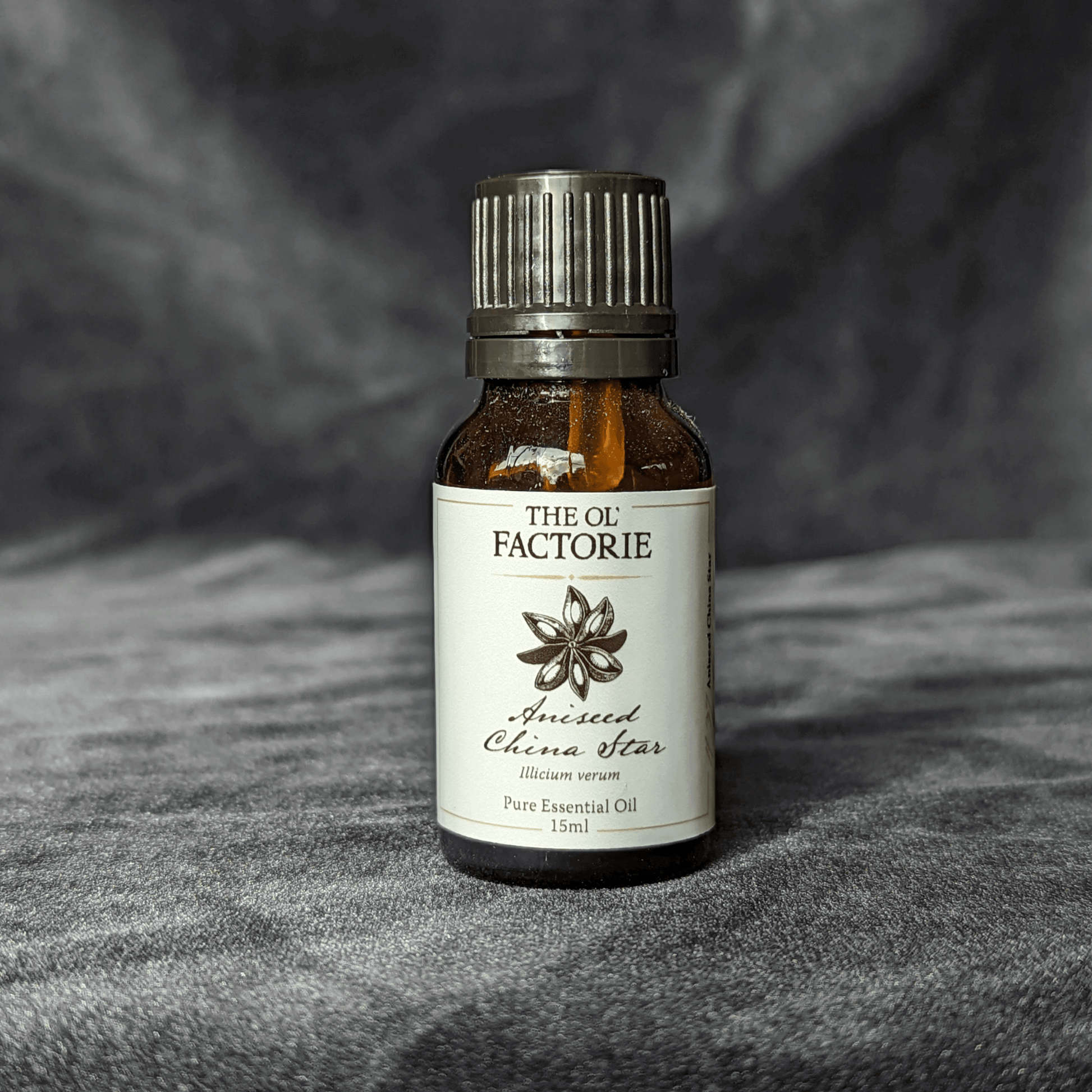 Photograph of 15ml Essential oil bottle of Aniseed China Star on black velvet background.